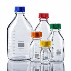 Five clear glass laboratory reagent bottles with different colored screw caps and printed volume markings, arranged on a white reflective studio background.